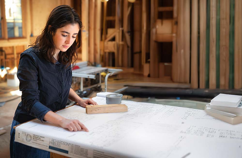 Alexandra Oliva Examines Plans on a Job Site